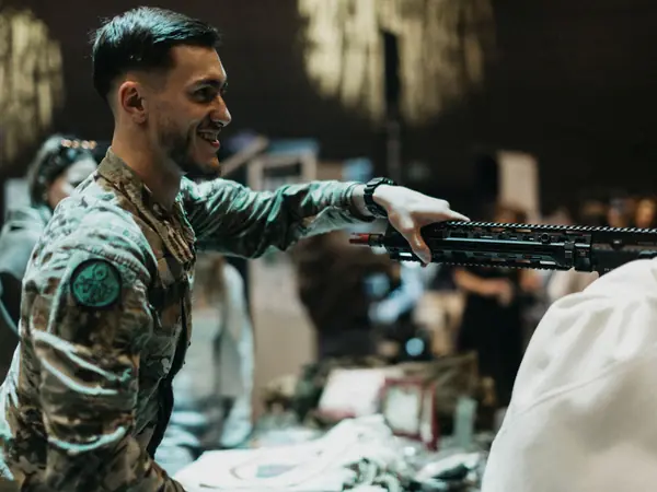 A soldier showing equipment to students at the Luxembourg Army stand