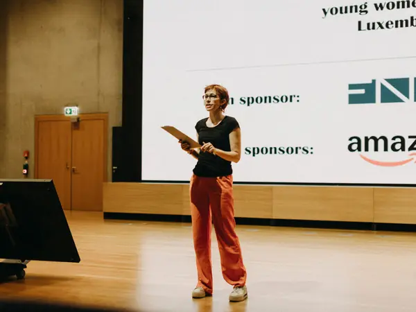 Welcome talk on stage, with the sponsors on screen