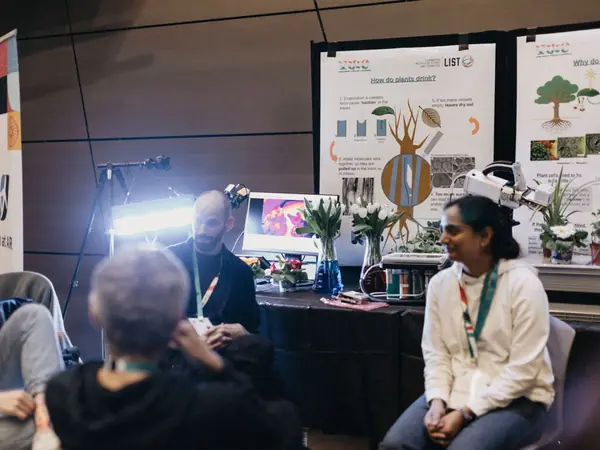 Students at an exhibitor stand with plant science posters