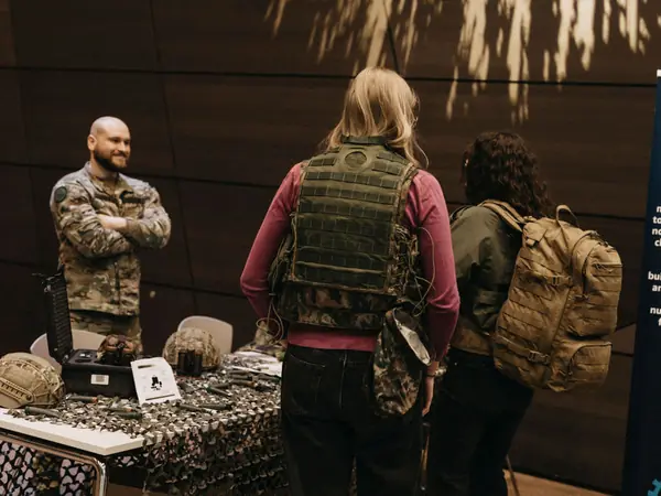 A student trying on a protective vest at the Luxembourg Army stand