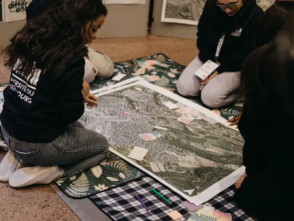 Students looking at a large aerial map spread on the floor