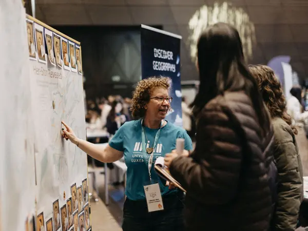 An exhibitor explaining a poster to students